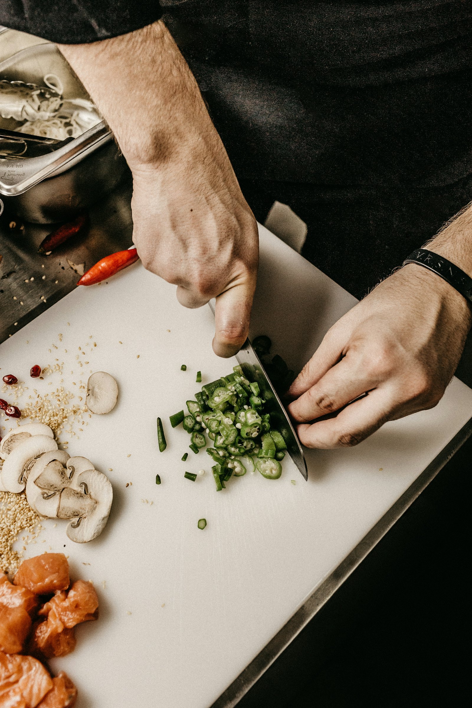 A chef plating fresh ingredients behind the pass